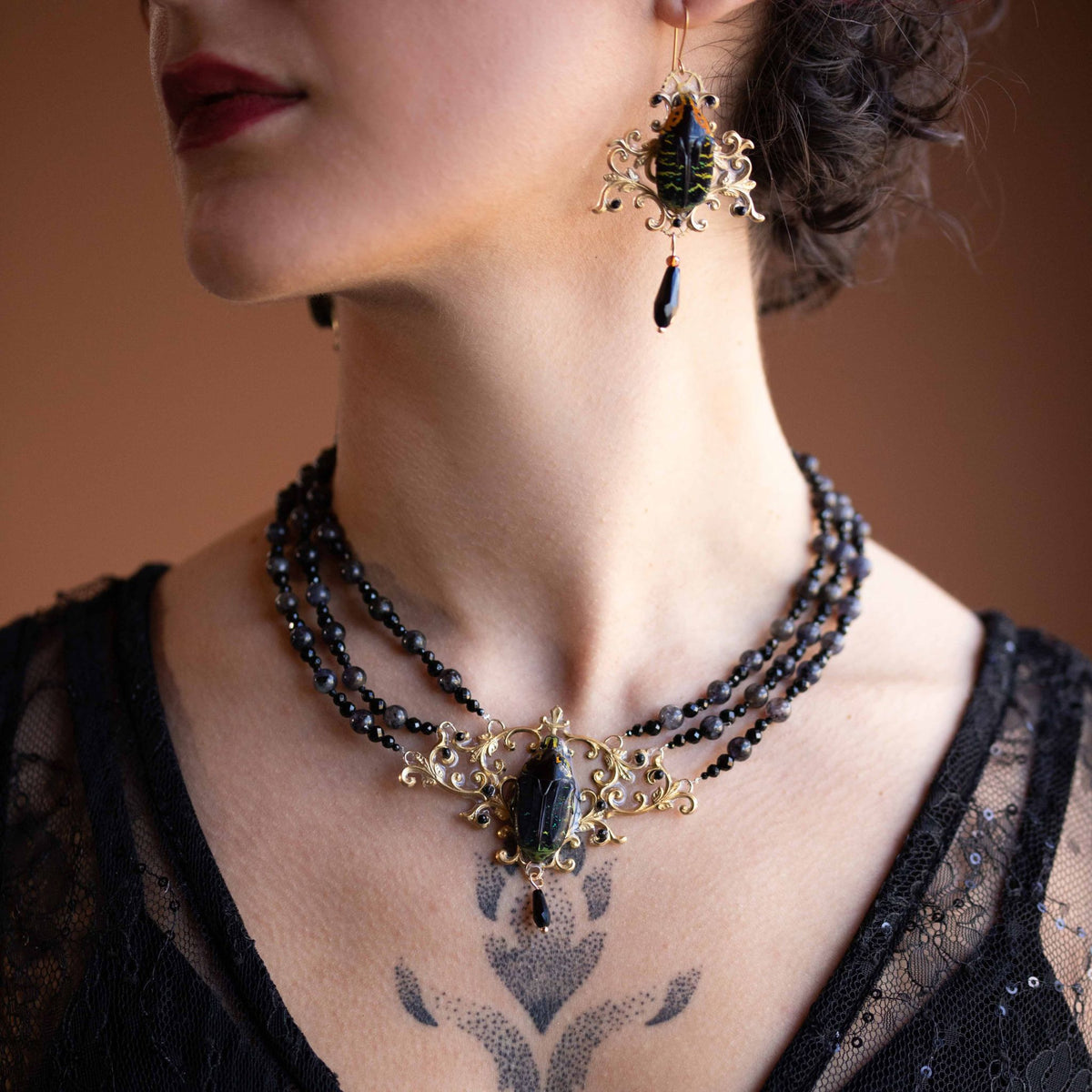 Collier Westwood noir porté de près – médaillon scarabée et goutte d'obsidienne | Victorian Rehab