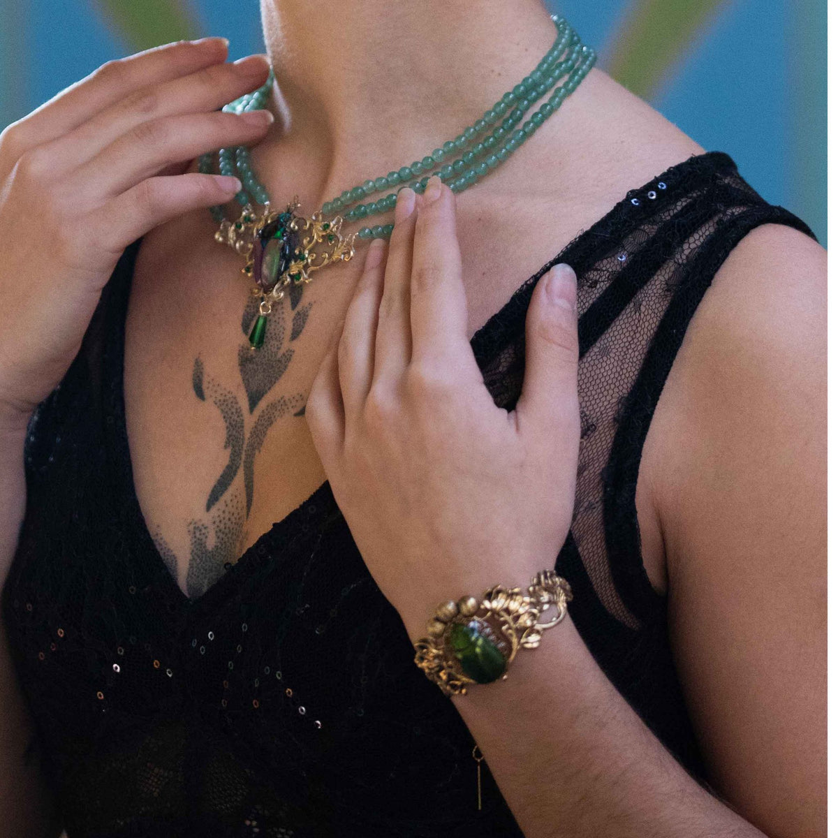 Collier Westwood vert porté de près – scarabée serti dans une estampe dorée | Victorian Rehab