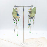 Boucles Naturalia portées, aux ailes vertes naturelles et monture dorée, bijou d'artisanat poétique