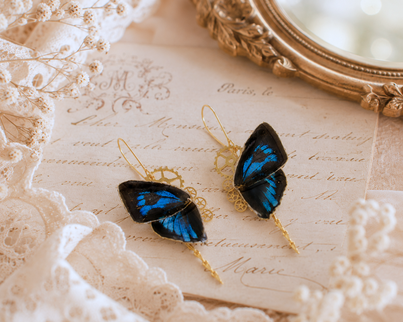 Détail boucles Aponi Ancema Ctesia – aile papillon bleu irisé noir laiton engrenage fait main Hérault